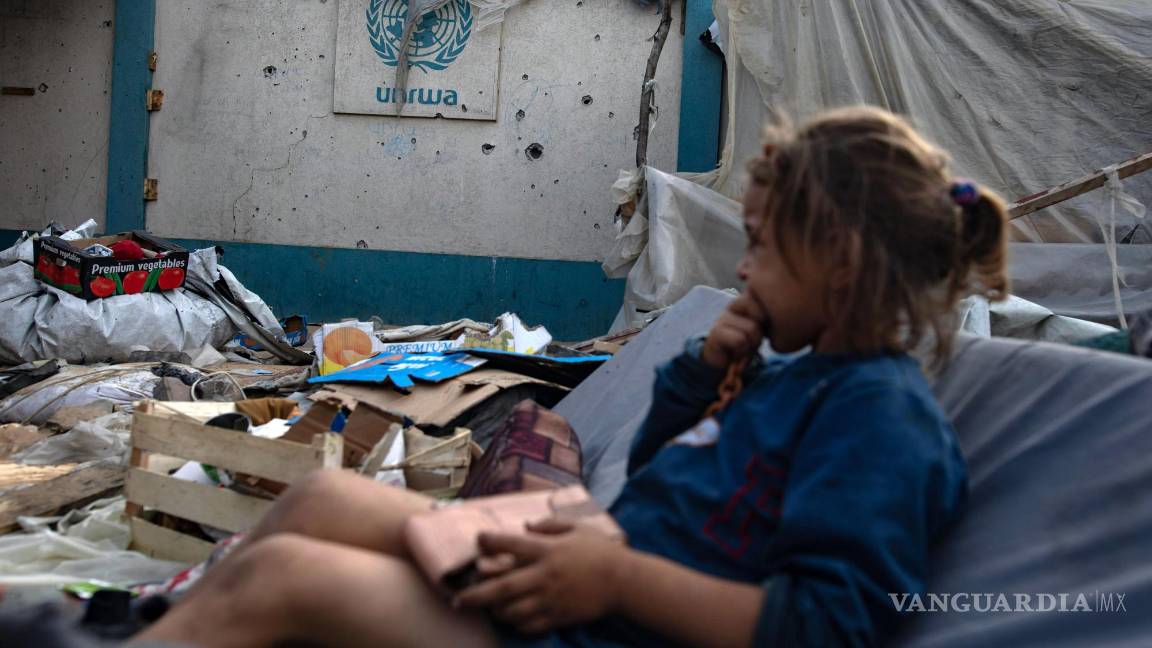 $!Una niña sentada junto a un logotipo de la UNRWA mientras los palestinos inspeccionan sus tiendas de campaña trasuna operación del ejército israelí.