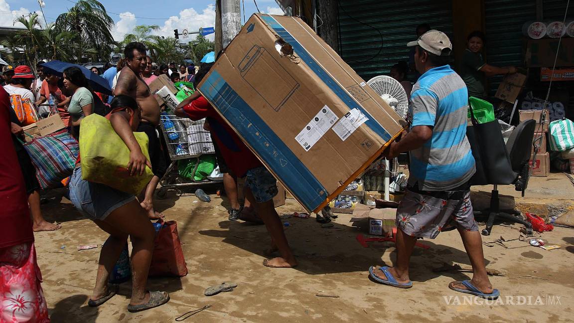 $!Fotografía que muestra personas mientras saquean tiendas de autoservicio por el paso del huracán Otis en el balneario de Acapulco, Guerrero (México).