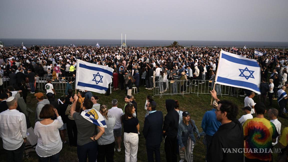 $!Personas con banderas israelíes en una vigilia organizada por la comunidad judía de Sydney en Dover Heights, al este de Sydney.