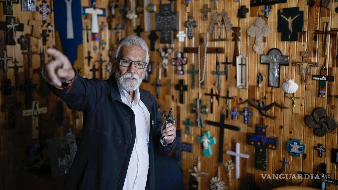 $!El cura jesuita Javier Ávila en una entrevista en su oficina decorada con cruces y crucifijos en Creel, México.