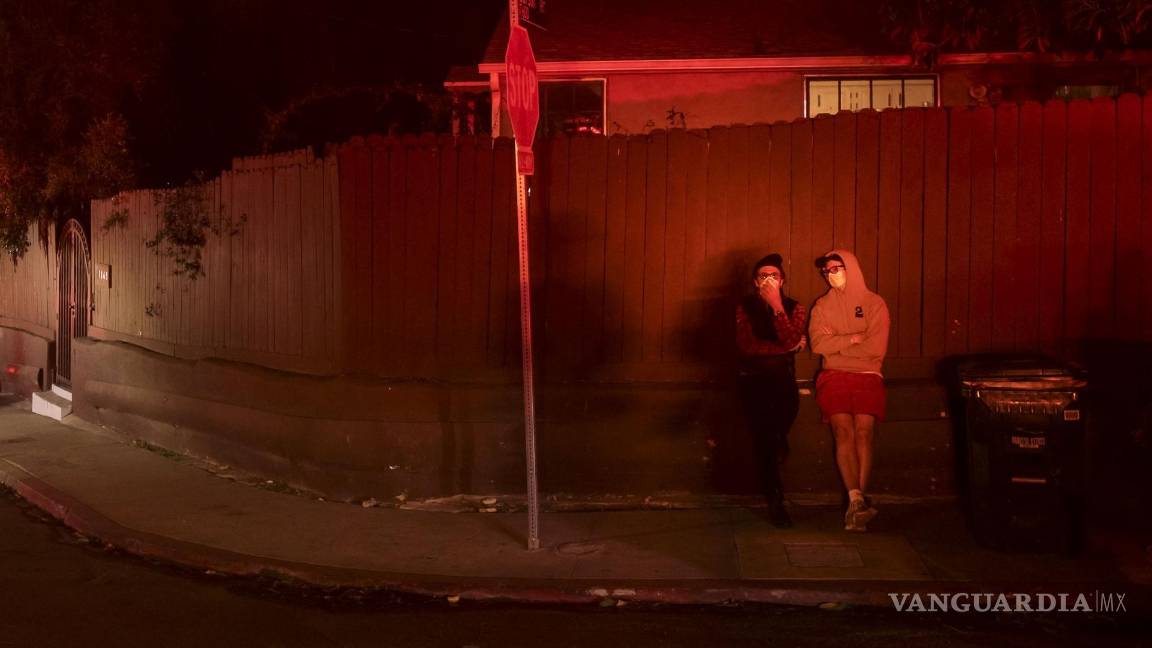 $!Dos personas observan el incendio forestal en Sunset en Los Ángeles. Las autoridades previnieron a los vecinos de que el agua no es potable.