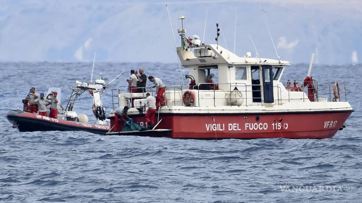 $!Buzos de los bomberos italianos llevan hasta un barco la bolsa con los restos mortales de una de las víctimas del naufragio del yate Bayesian en Porticello.