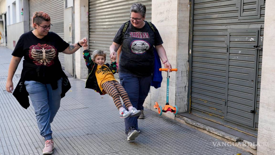$!Anastasia Domini, a la izquierda, y su esposa, Anna, se dirigen con su hija a un parque en Buenos Aires, Argentina.