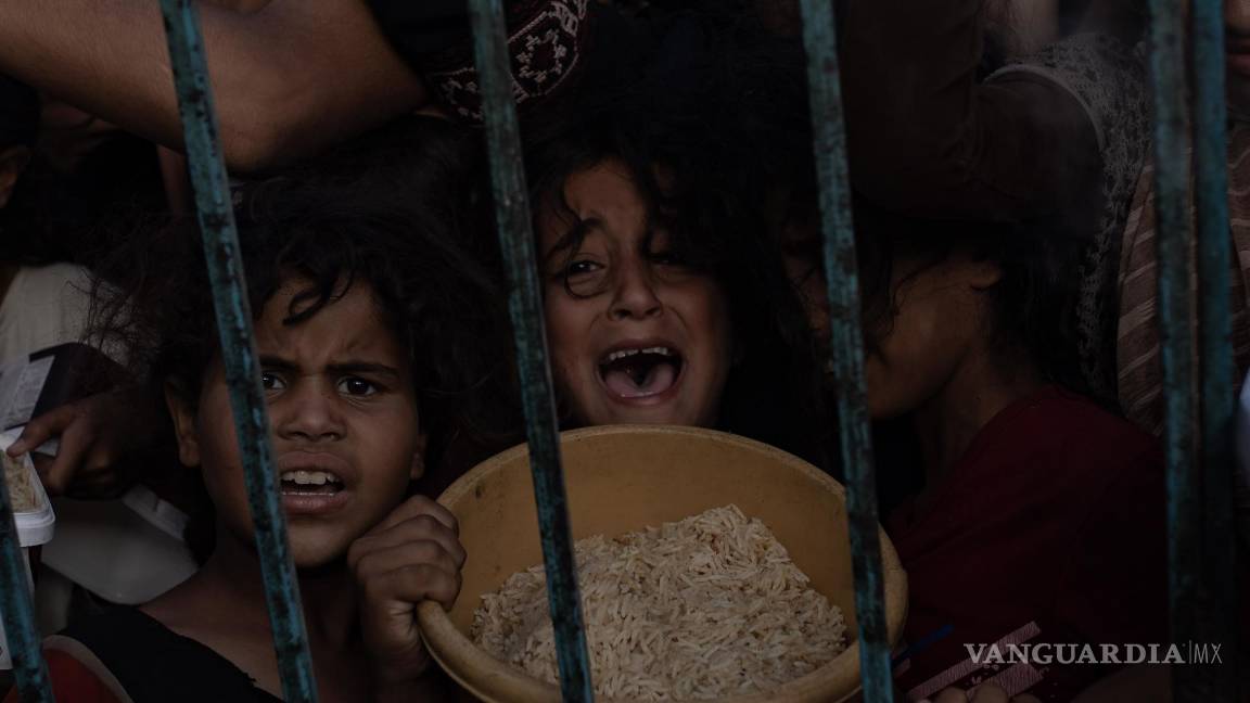 $!Niños en una reunión de palestinos desplazados para recoger alimentos donados por un grupo caritativo, en el campamento de Khan Yunis, en la Franja de Gaza.