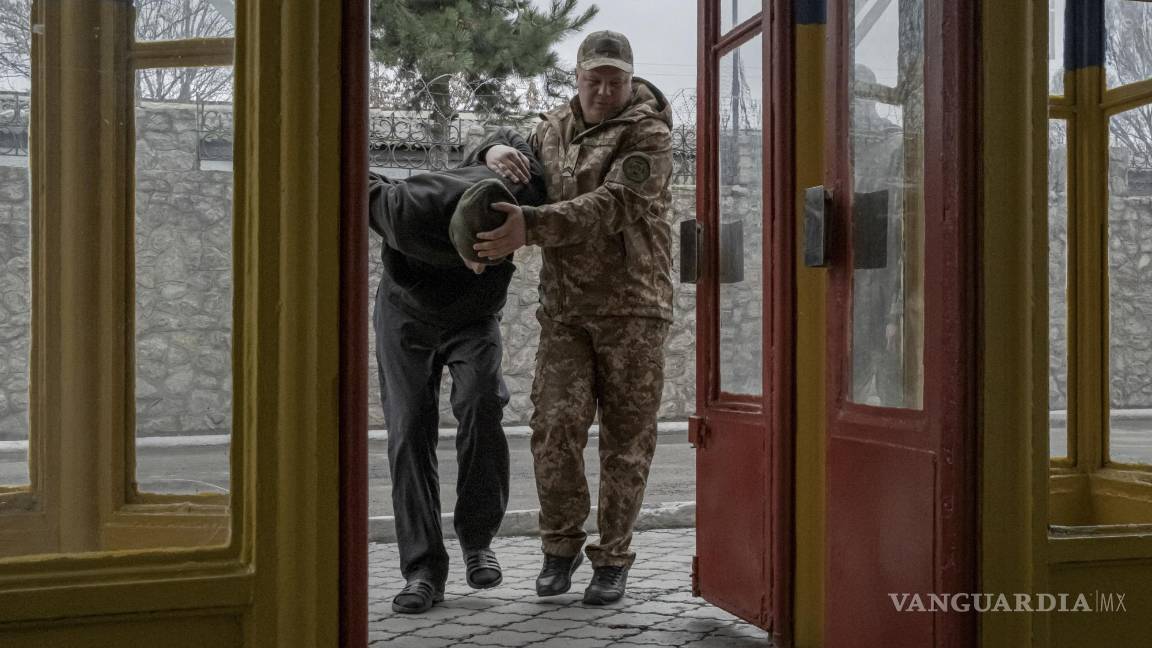 $!Un soldado de Wagner capturado es escoltado por un guardia ucraniano en una prisión en Dnipro.