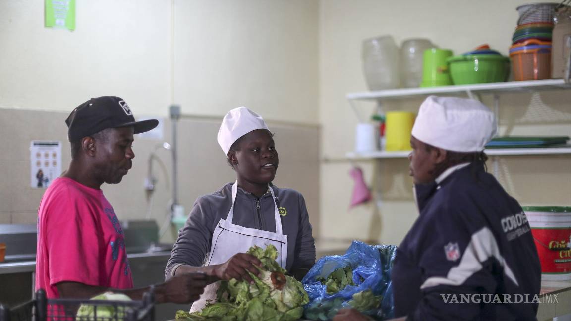 $!Migrantes de origen haitiano preparan alimentos en las instalaciones de la organización Cafemin en la Ciudad de México (México).