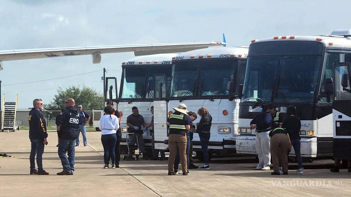 $!Oficiales de migración mientras requisan a unos migrantes antes de ser deportados en grupo en el Aeropuerto de Harlingen.