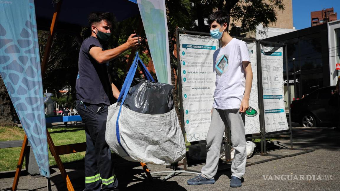$!Un joven entrega una bolsa con plásticos para reciclar, el 16 de febrero de 2022, en Montevideo, Uruguay.