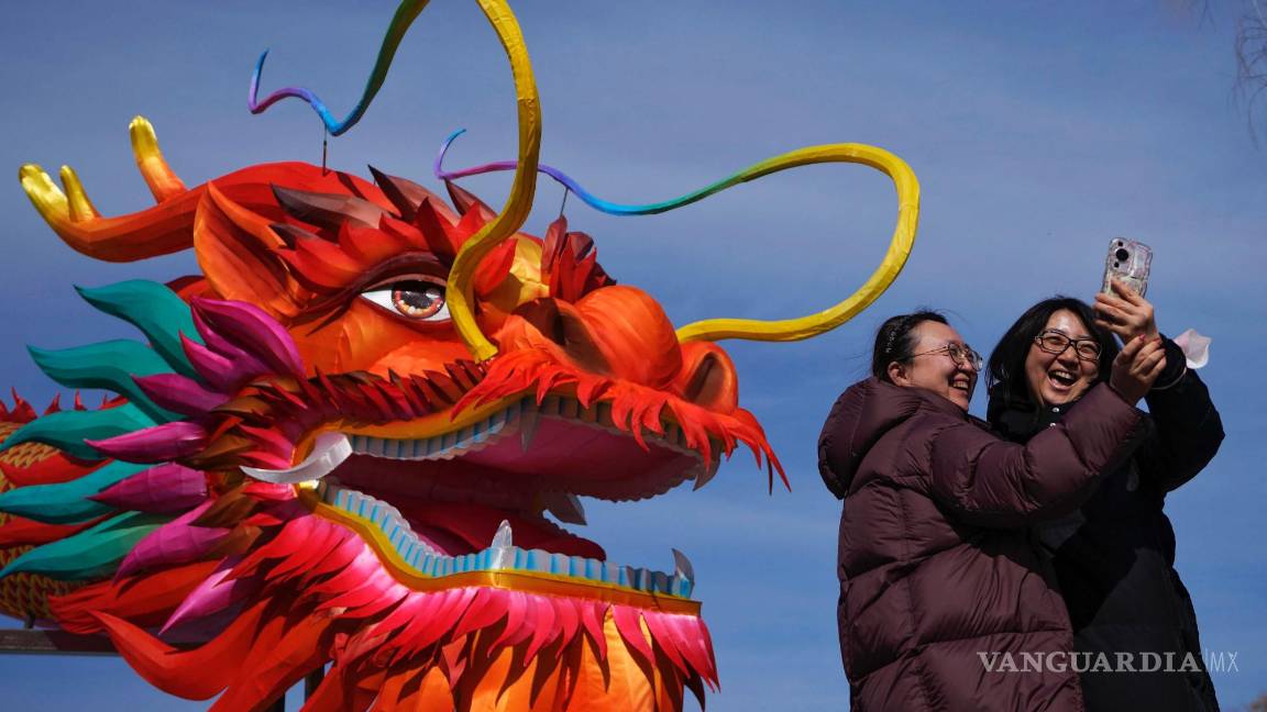 $!Dos mujeres se toman un selfie delante de una linterna gigante con forma de dragón en el lago Houhai, en Beijing.