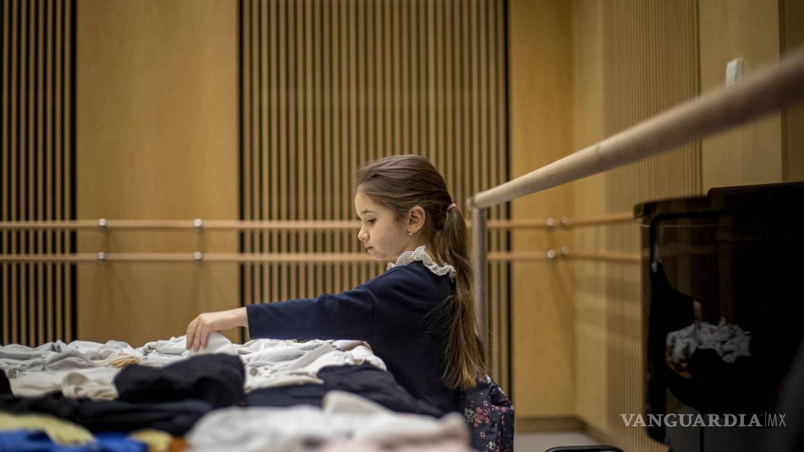$!Una niña elige ropa de baile recolectada antes de la lección de ballet organizada por la Escuela Preparatoria de Ballet del Teatro Nacional.