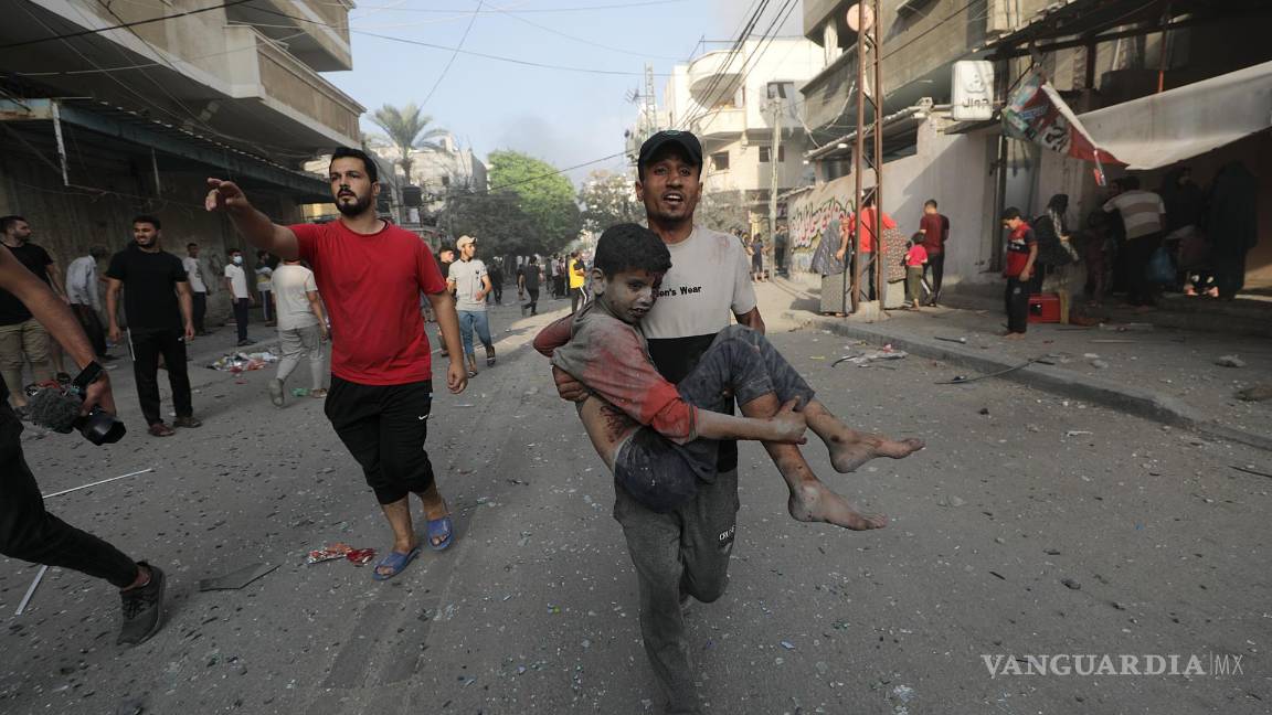 $!Un palestino carga a un niño herido tras un ataque aéreo israelí en el norte de Gaza.