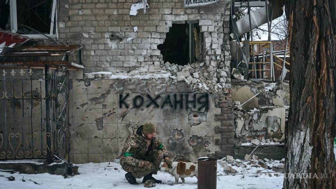 $!Un soldado ucraniano acaricia a un perro en Bakhmut, Ucrania. El letrero en la pared dice “Amor”, el letrero de la calle dice “Calle de la Independencia”.