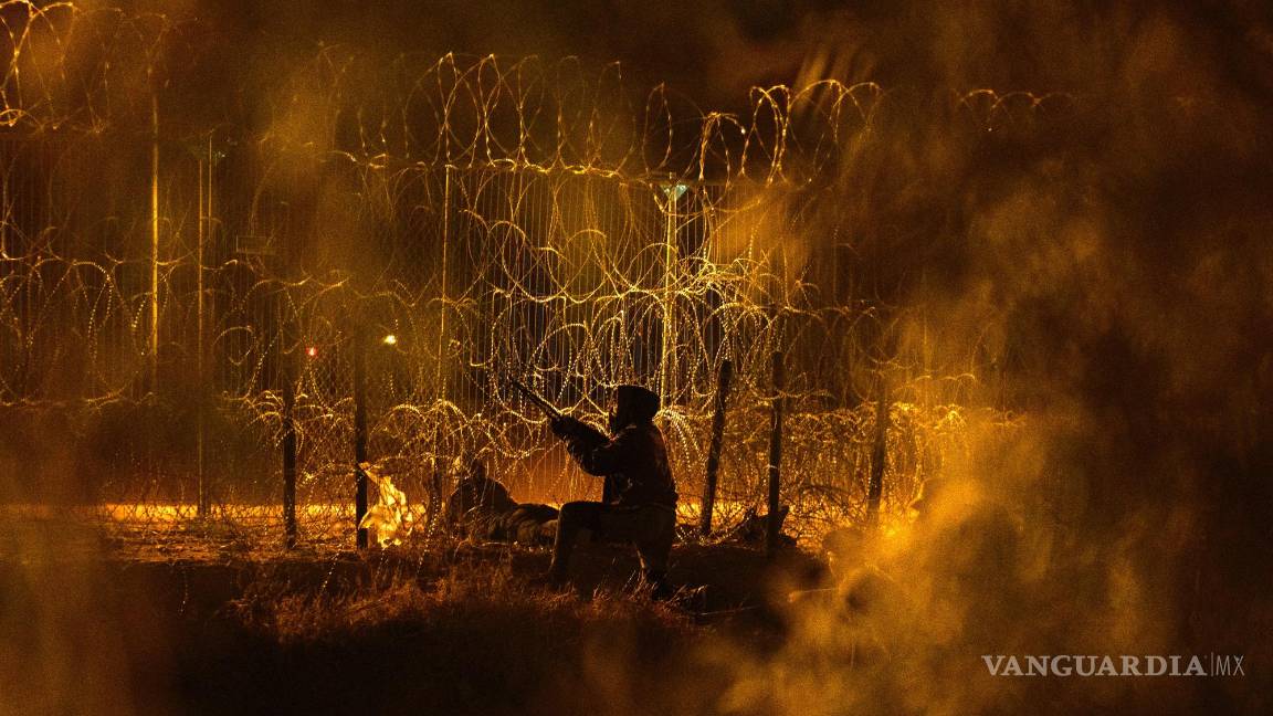 $!Un hombre intenta hacer un agujero en la valla construida a lo largo de la frontera entre Estados Unidos y México en Ciudad Juárez, México, el 4 de junio de 2024.