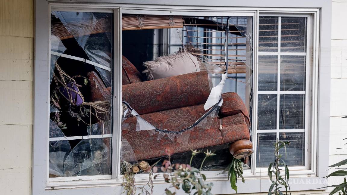 $!Un sofá atravesó las ventanas delanteras de una casa después de las catastróficas inundaciones causadas por la tormenta tropical Helene en Swannanoa.