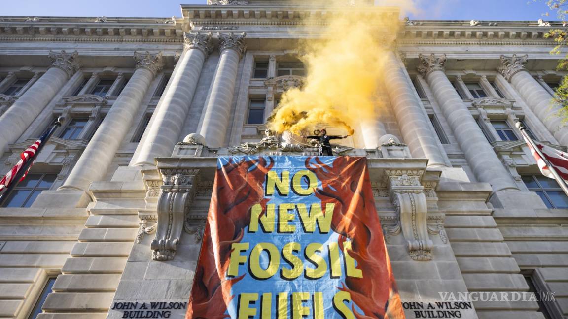 $!Activistas del grupo ambientalista Extinction Rebellion (XRDC) cuelgan una pancarta del Edificio Wilson, la sede del gobierno local de DC, en Washington.