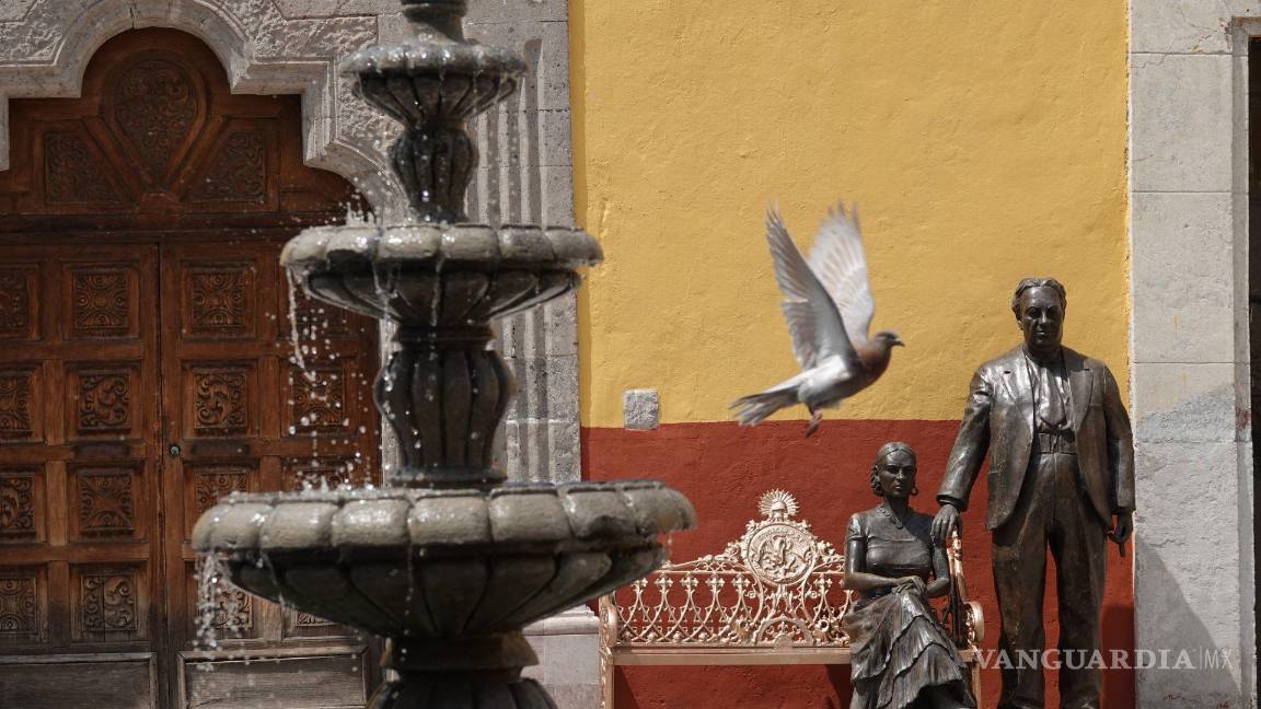 $!Una paloma vuela enfrente de una escultura de los pintores Diego Rivera y Frida Kahlo, en la alcaldía Coyoacán.
