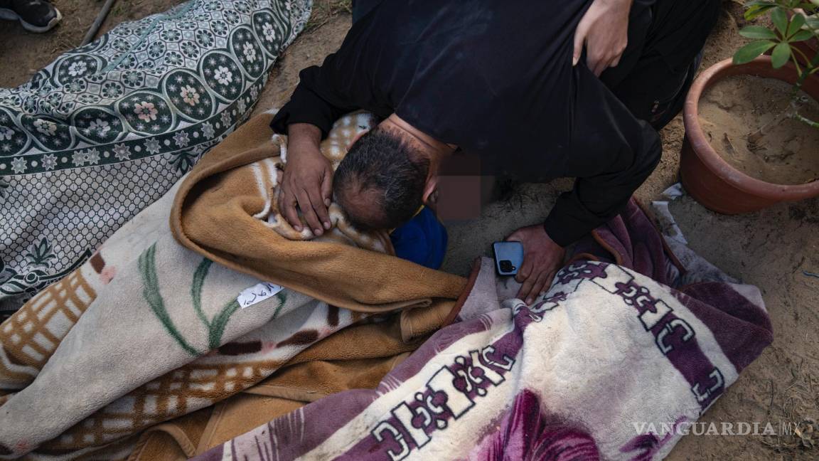 $!Palestinos llorando a parientes muertos en un bombardeo israelí sobre la Franja de Gaza, en una morgue de Khan Younis.