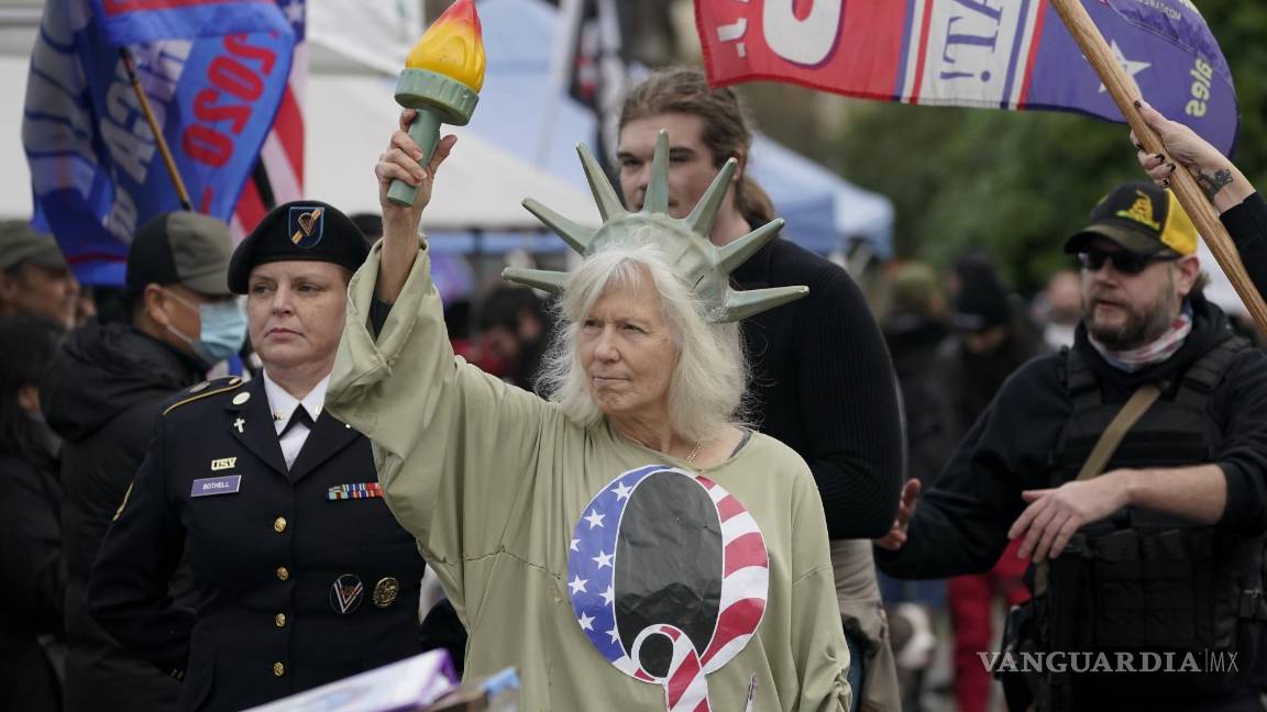 $!En esta imagen del 6 de enero de 2021, una persona vestida como la Dama de la Libertad porta una camiseta con la letra Q, en referencia a QAnon, mientras manifestantes realizan una protesta en el Capitolio de Olympia, Washington, en contra del conteo de votos electorales en Washington DC, para ratificar la victoria del presidente electo, Joe Biden. AP/Ted S. Warren