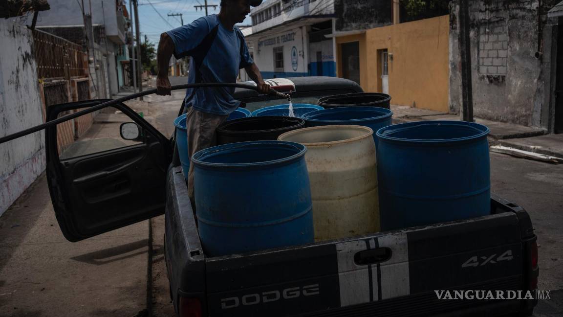 $!Un hombre llena bidones con agua debido a la escasez causada por las altas temperaturas y la sequía en Veracruz, México.