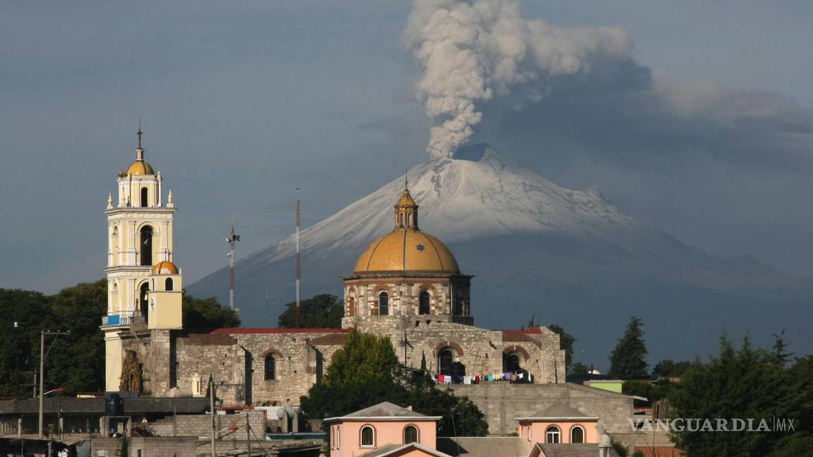 $!La iglesia principal de San Damián Texoloc, Tlaxcala, en México, al frente del volcán Popocatépetl mientras expulsa cenizas y vapor a inicios de julio de 2013.