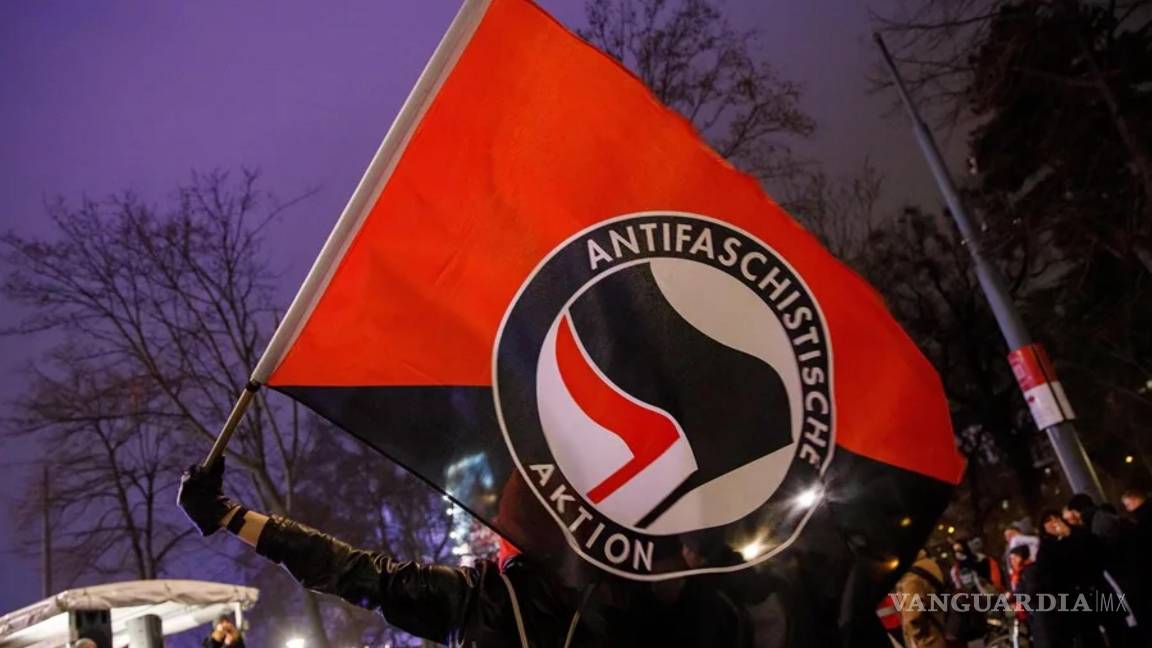 $!Una persona con una bandera del grupo “Informal Anarchist Federation”, “Federación Anarquista Internacional” en español.