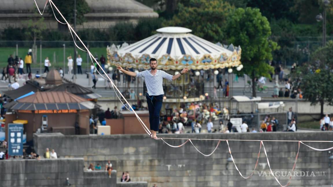 $!El acróbata francés Nathan Paulin camina por una línea alta desde la Torre Eiffel a través del río Sena, como parte de los eventos en Francia para los Días del Patrimonio Nacional en París. AP/Alain Jocard