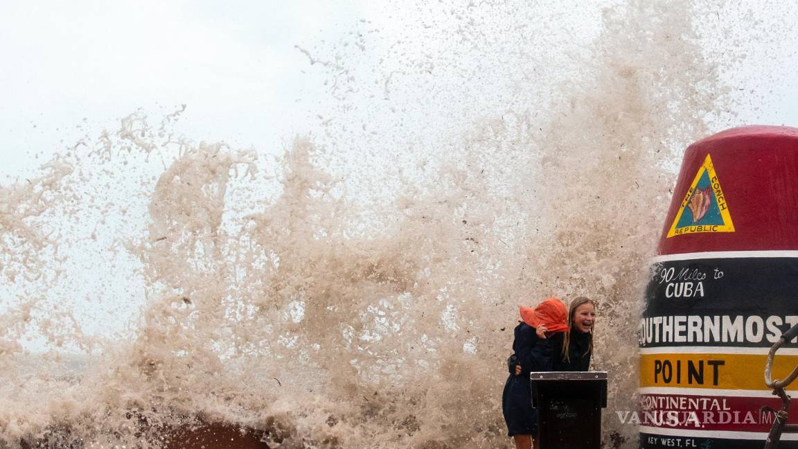 $!Los visitantes de la boya de Southernmost Point desafían las altas olas del huracán Ian para tomar fotos en Key West, Florida.