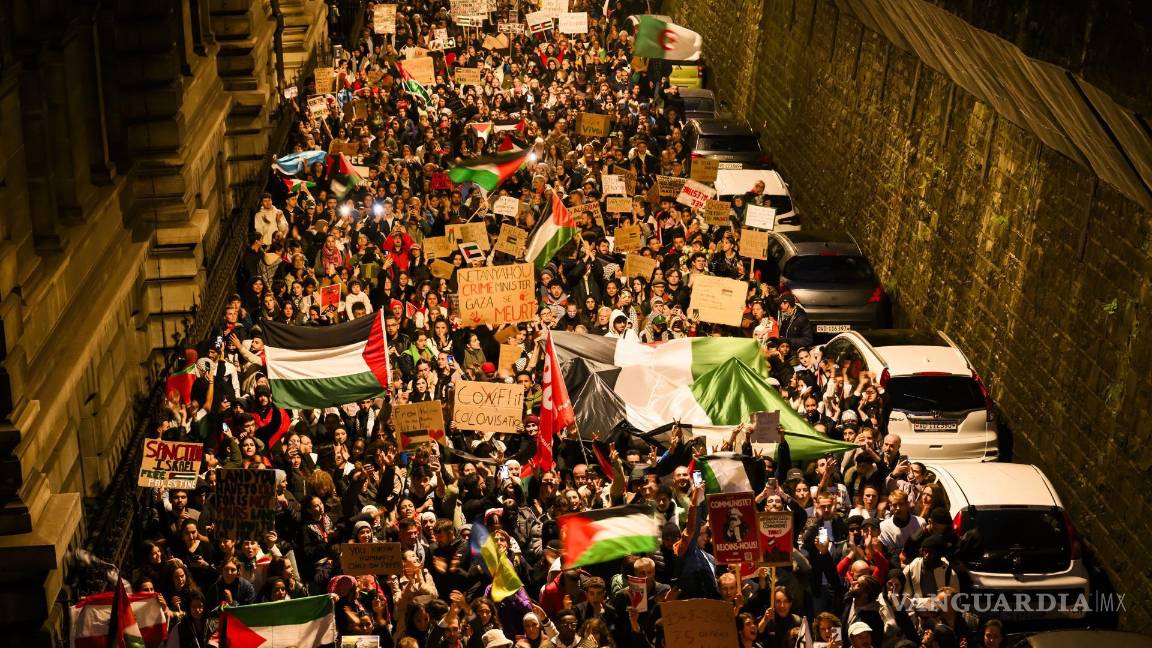 $!Los manifestantes sostienen pancartas y banderas palestinas durante una manifestación en apoyo del pueblo palestino en Lausana, Suiza.