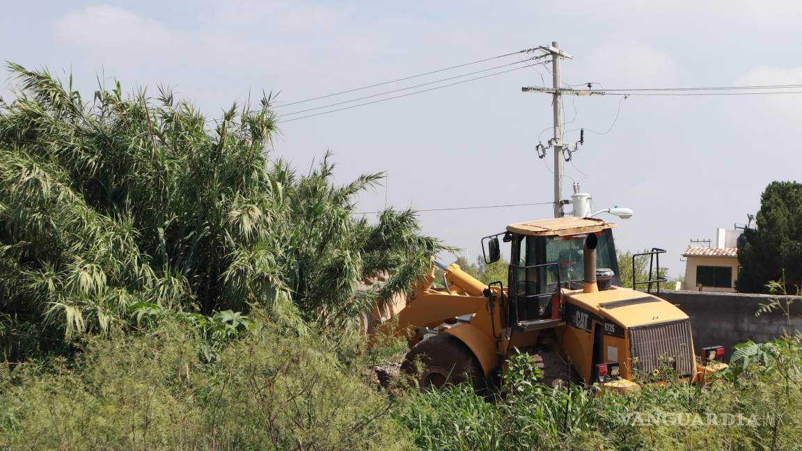 $!En la zona de Villa Bonita, maquinaria pesada intervino el cauce de un arroyo para retirar maleza y escombros, tras las afectaciones de este martes.