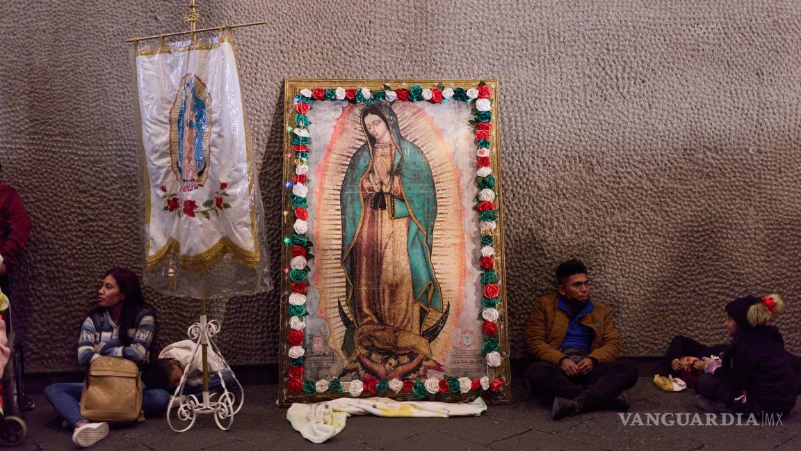 $!Peregrinos descansan junto a una imagen de la Virgen de Guadalupe en el exterior de su basílica, en la Ciudad de México, el 11 de diciembre de 2025.