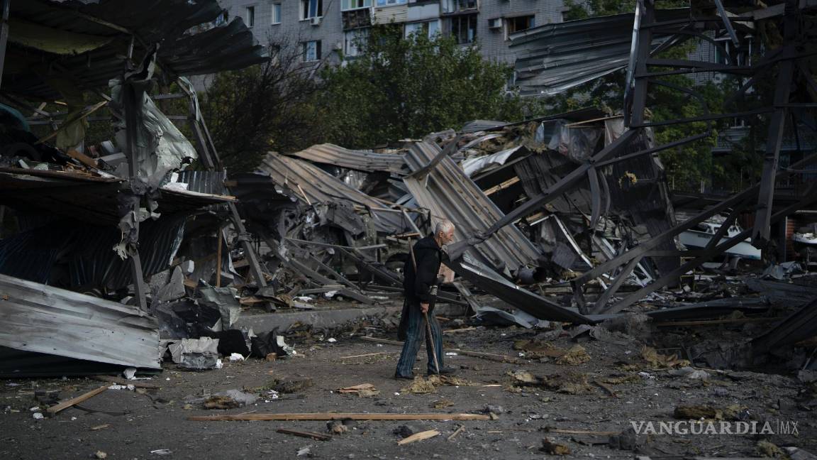 $!Un anciano pasa junto a un concesionario de autos destruido por un ataque ruso en Zaporiyia, Ucrania.