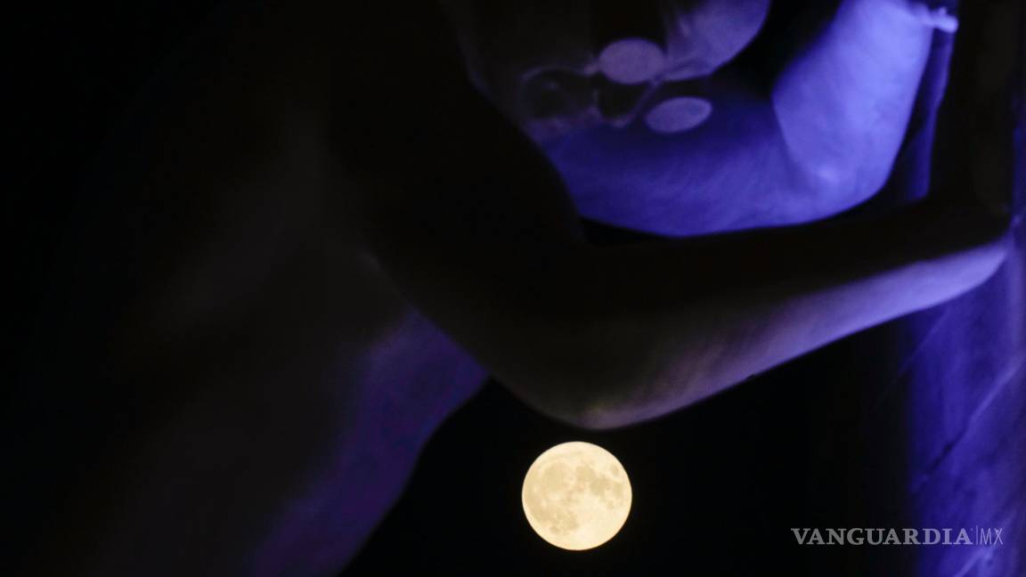 $!La luna llena, vista detrás de la escultura Mr Arbitrium, del artista Emanuele Giannelli, que se apoya en el Arco de la Paz, en Milán, Italia, el 13 de julio de 2022.