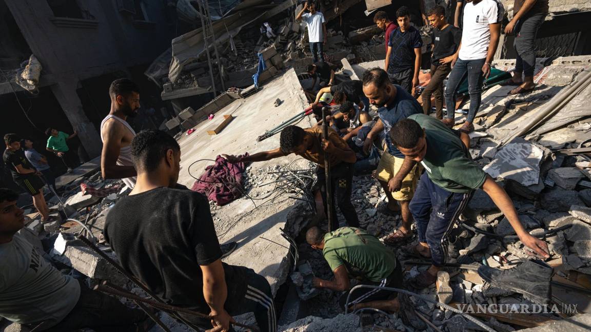 $!Palestinos buscan cadáveres y sobrevivientes entre los restos de un edificio residencial arrasado tras un ataque aéreo israelí sobre el campo de refugiados.