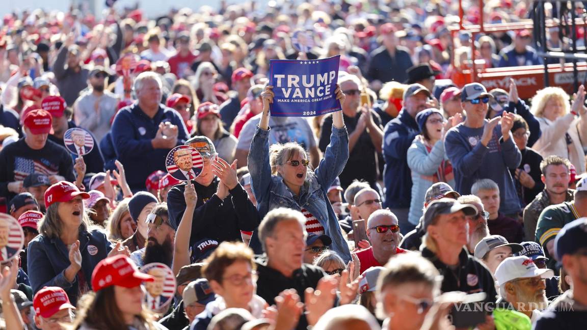 $!Partidarios escuchan al candidato presidencial republicano Donald Trump en un mitin de campaña en el aeropuerto del condado de Dodge en Juneau, Wisconsin.