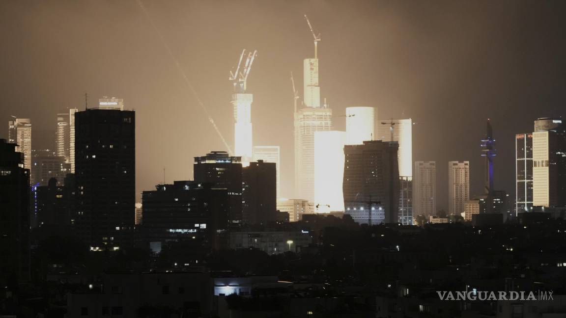 $!Una explosión causada por el impacto de un proyectil ilumina el horizonte de Tel Aviv, Israel, a primera hora de la mañana.