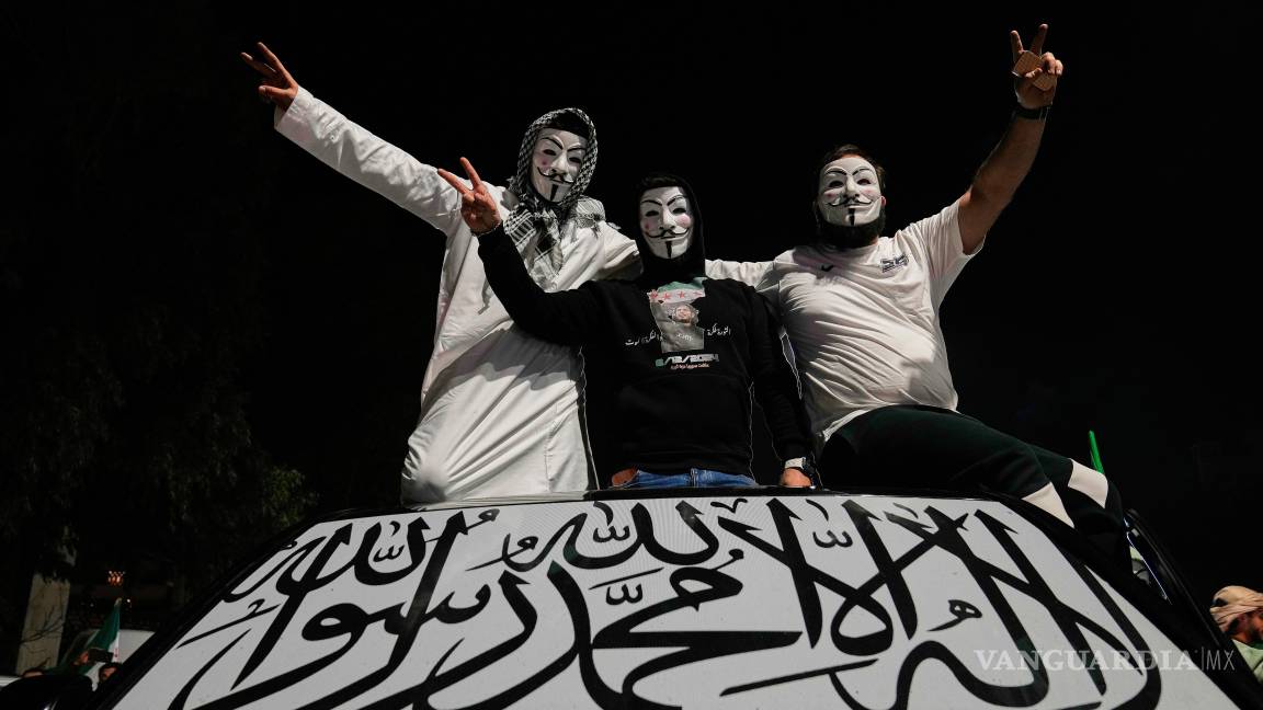 $!Hombres sirios sobre su auto con el parabrisas cubierto con una bandera islámica, celebranel primer aniversario de la caída del gobierno autócrata de Bashar Assad.