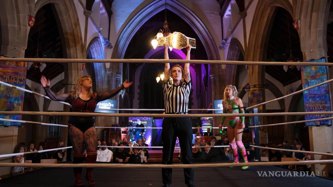 $!La árbitro Katie Crosby sostiene el cinturón en disputa antes del combate de Kiara contra Scarlett, izquierda, durante un espectáculo de Kingdom Wrestling.