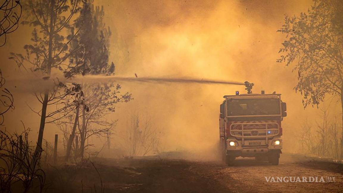 $!Esta foto proporcionada por el SDIS 33 muestra a un camión de bomberos rociando líquido sobre un incendio forestal cerca de Landiras, suroeste de Francia.