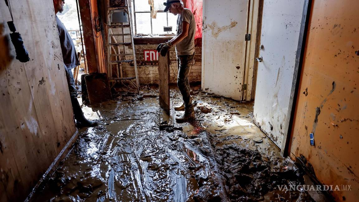 $!Una mujer hace una pausa mientras ayuda a limpiar el lodo de The Asheville Guitar Bar en el River Arts District en Asheville, Carolina del Norte.
