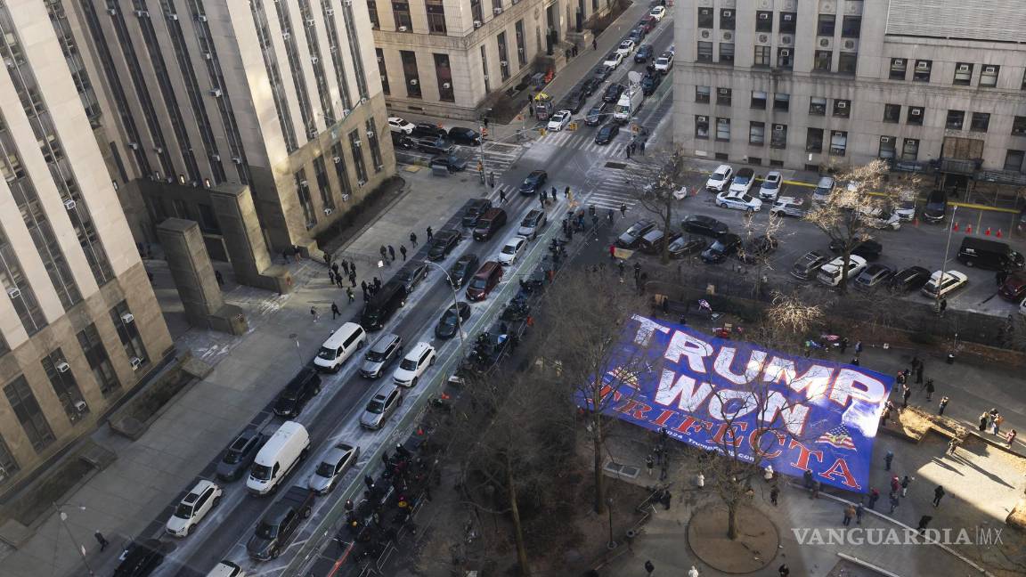 $!Partidarios del presidente electo Donald Trump, sostienen una pancarta gigante afuera del Tribunal Penal de Nueva York.