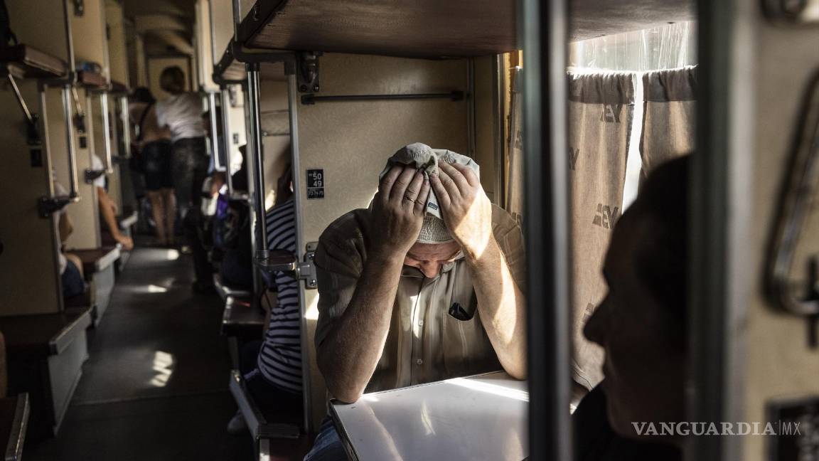 $!Un hombre sostiene su cabeza entre sus manos mientras toma asiento en un tren que evacua a los residentes de Pokrovsk, Ucrania.