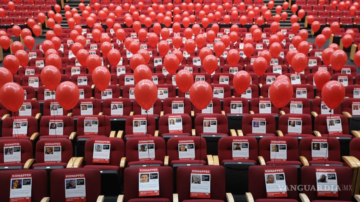 $!Fotografías de 224 rehenes israelíes y globos rojos están adheridas a los asientos en el teatro del Centro Internacional de Convenciones en Jerusalén, Israel.