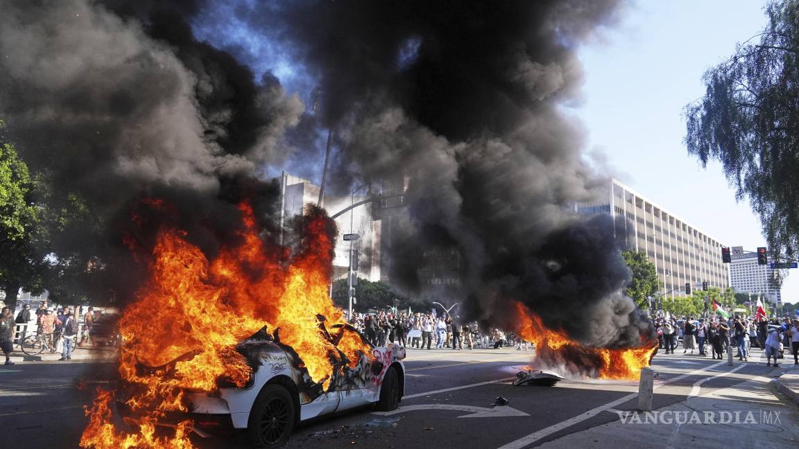 $!Dos taxis Waymo arden cerca del centro de detención metropolitano del centro de Los Ángeles luego de la protesta por la redada de inmigración de anoche.