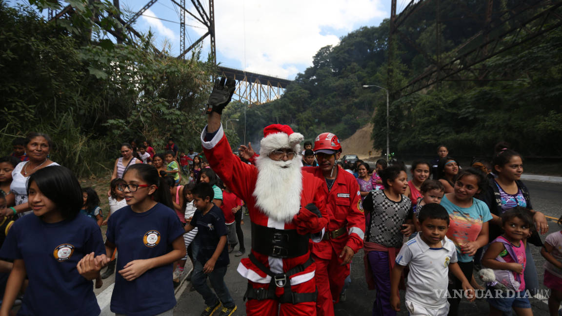 Santa en Guatemala salta de un puente para dar regalos a los niños pobres