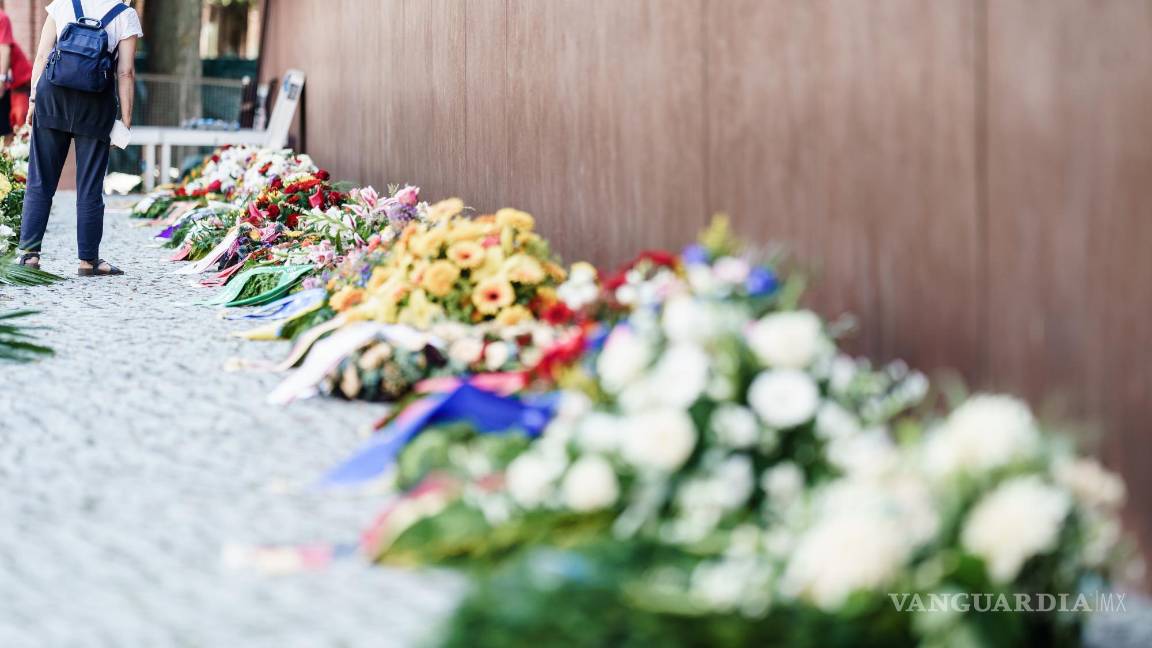 $!Una mujer mira coronas de flores después de la ceremonia de conmemoración del 60 aniversario de la construcción del Muro de Berlín en el Monumento al Muro de Berlín en Berlín, Alemania. EFE/EPA/Clemens Bilan