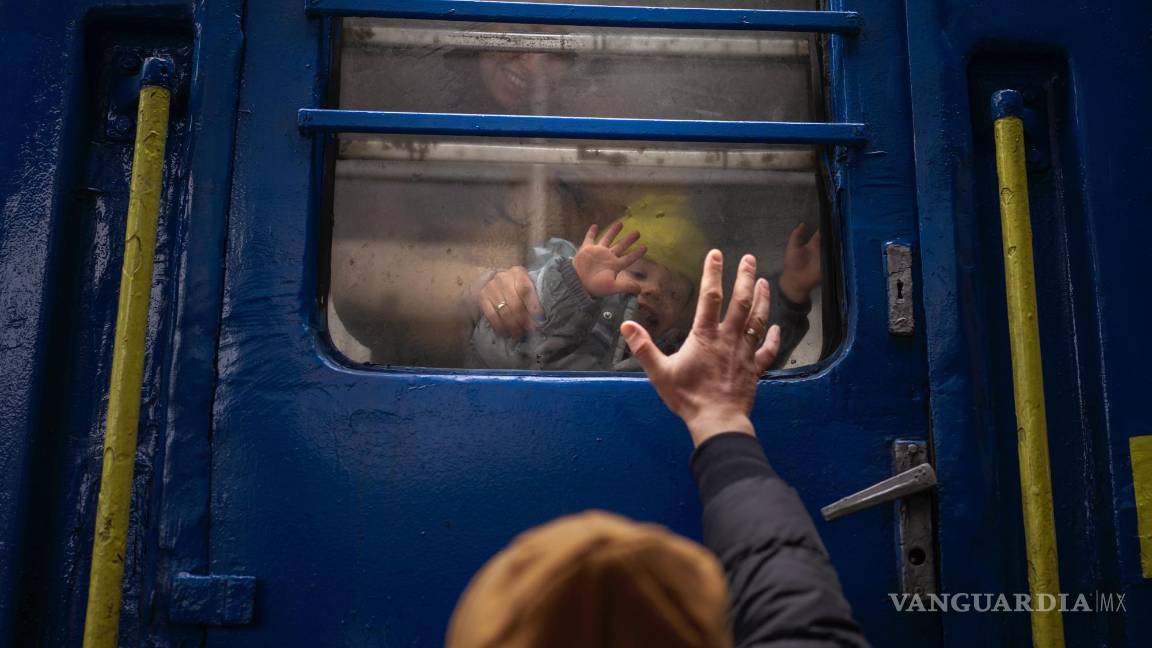 $!Stanislav se despide de su hijo de dos años David y de su esposa Anna luego de que embarcasen en un tren que los llevaría a Leópolis, en la estación de Kiev, Ucrania.