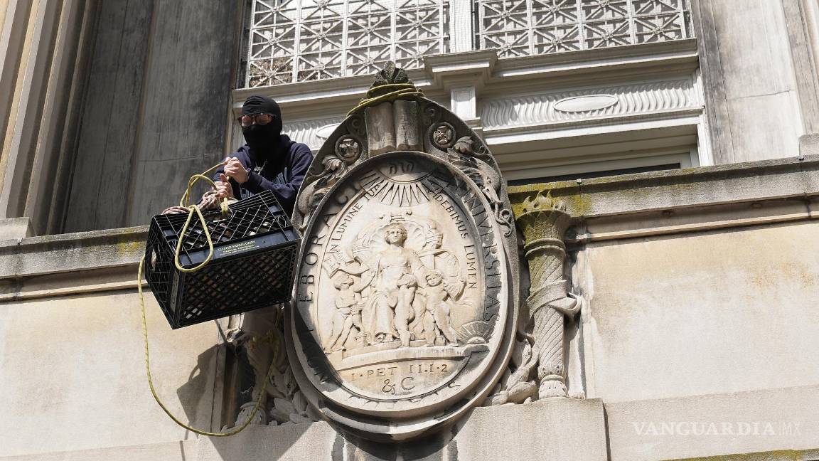 $!Un estudiante manifestante saca una caja llena de alimentos y suministros desde un balcón de Hamilton Hall en el campus de la Universidad de Columbia.