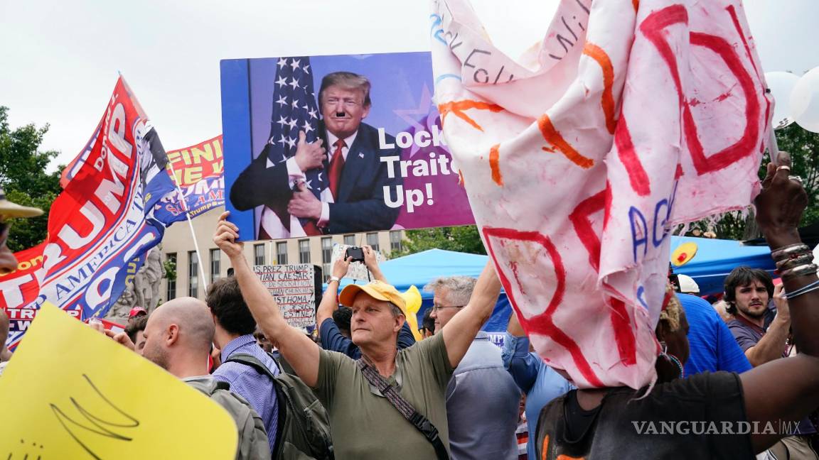 $!Eric Lamar sostiene un cartel contra Trump mientras está rodeado de manifestantes y simpatizantes del expresidente Donald Trump en Washington.