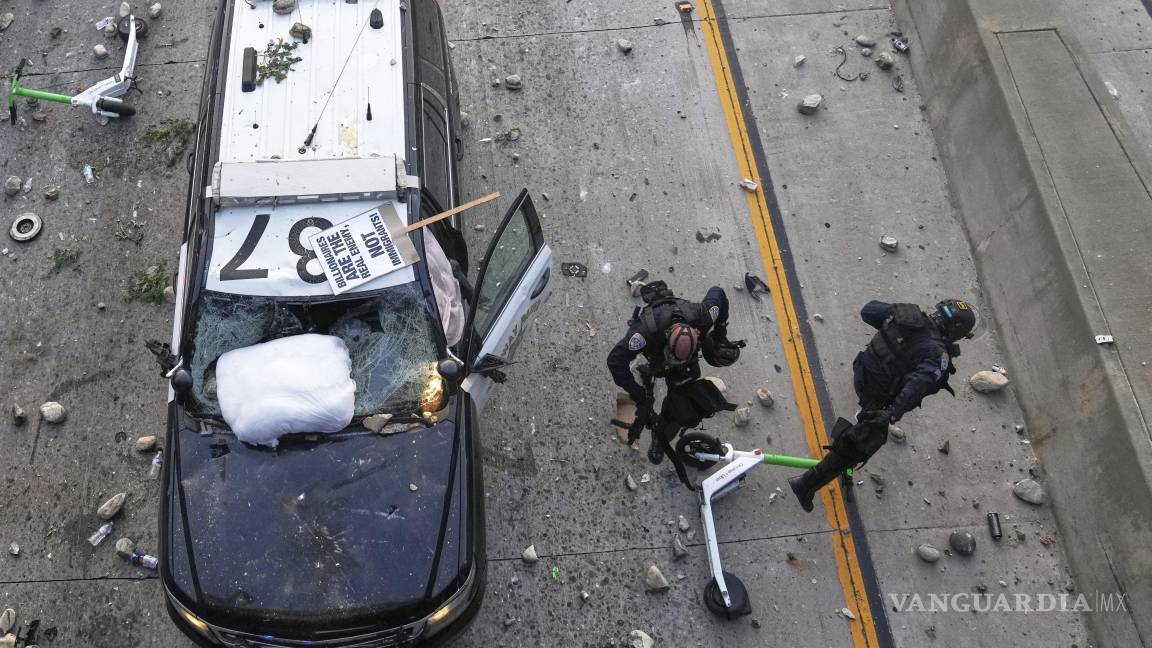 $!Dos agentes de la Patrulla de Carreteras de California intentan esquivar piedras lanzadas cerca del Centro de Detención Metropolitano en el centro de Los Ángeles.