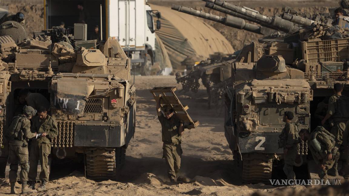 $!Soldados israelíes trabajan en sus vehículos blindados estacionados en una zona de preparación cerca de la frontera entre Israel y Gaza.